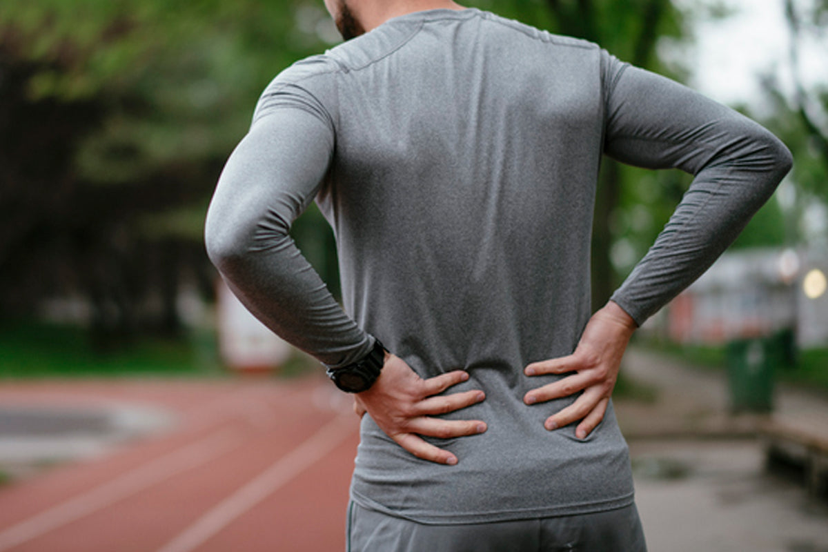 man holding his lower back in pain