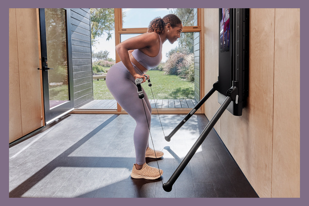 Woman resistance training at home with Tonal.