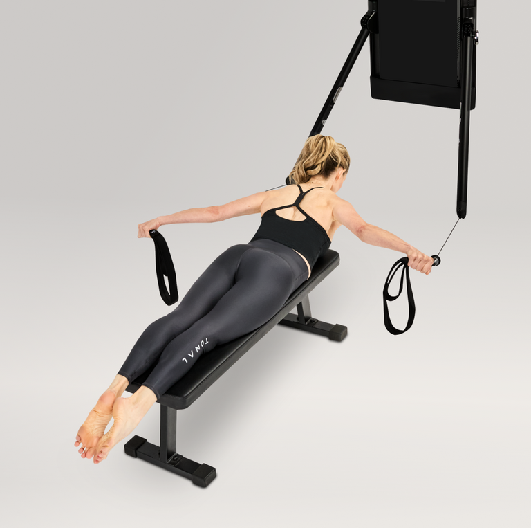 Person using a Tonal machine and Pilates loops