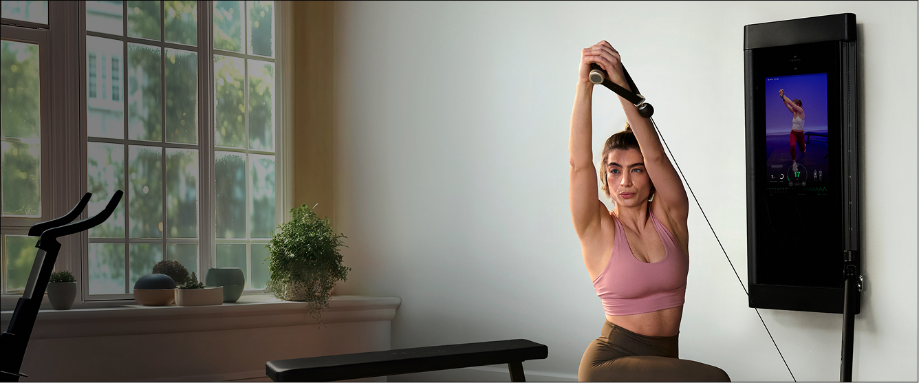 Woman exercising using Tonal weight training system in a home setting