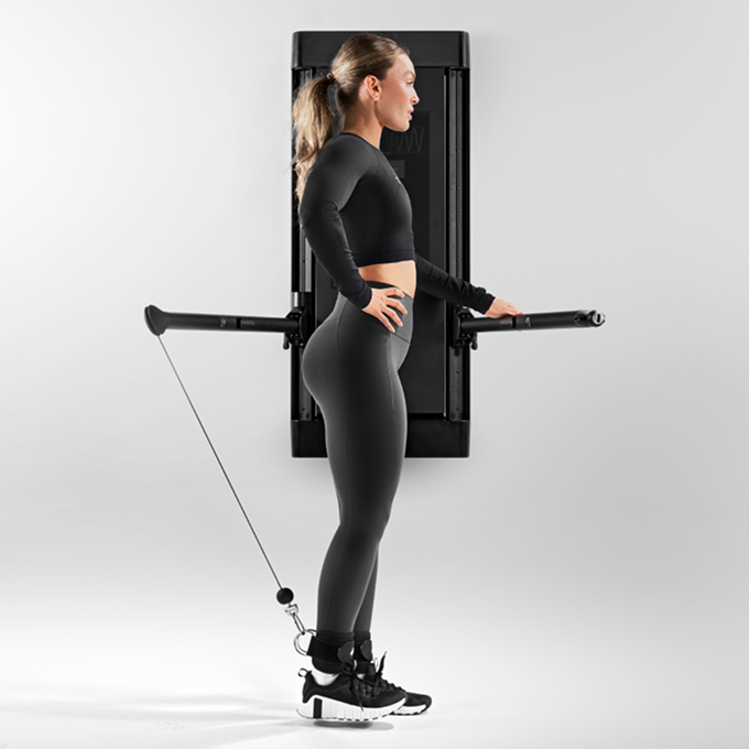 Woman using Tonal ankle straps in her workout