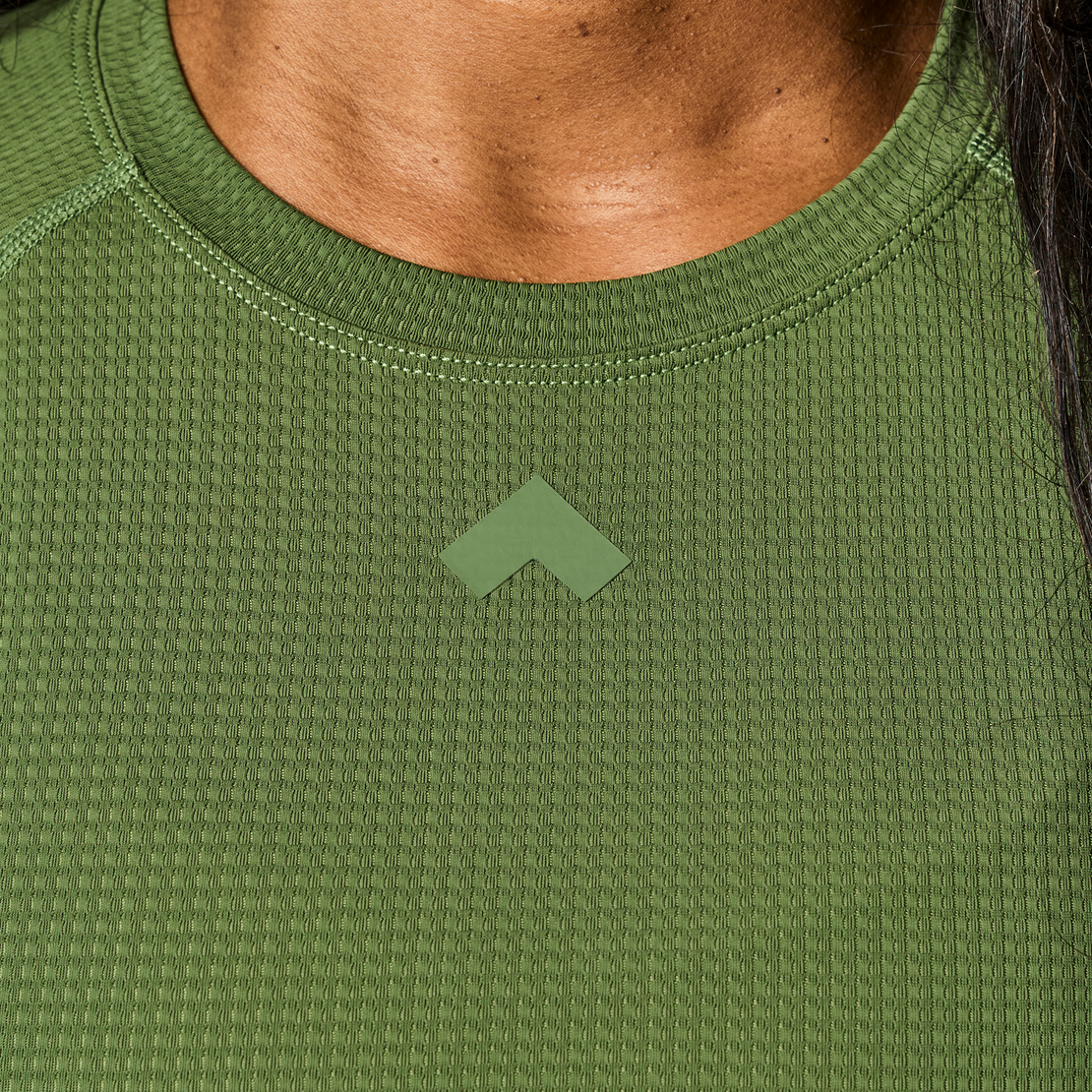 Close up of Dark Sage Tonal Performance Lifestyle Tee fabric and Tonal logo on chest