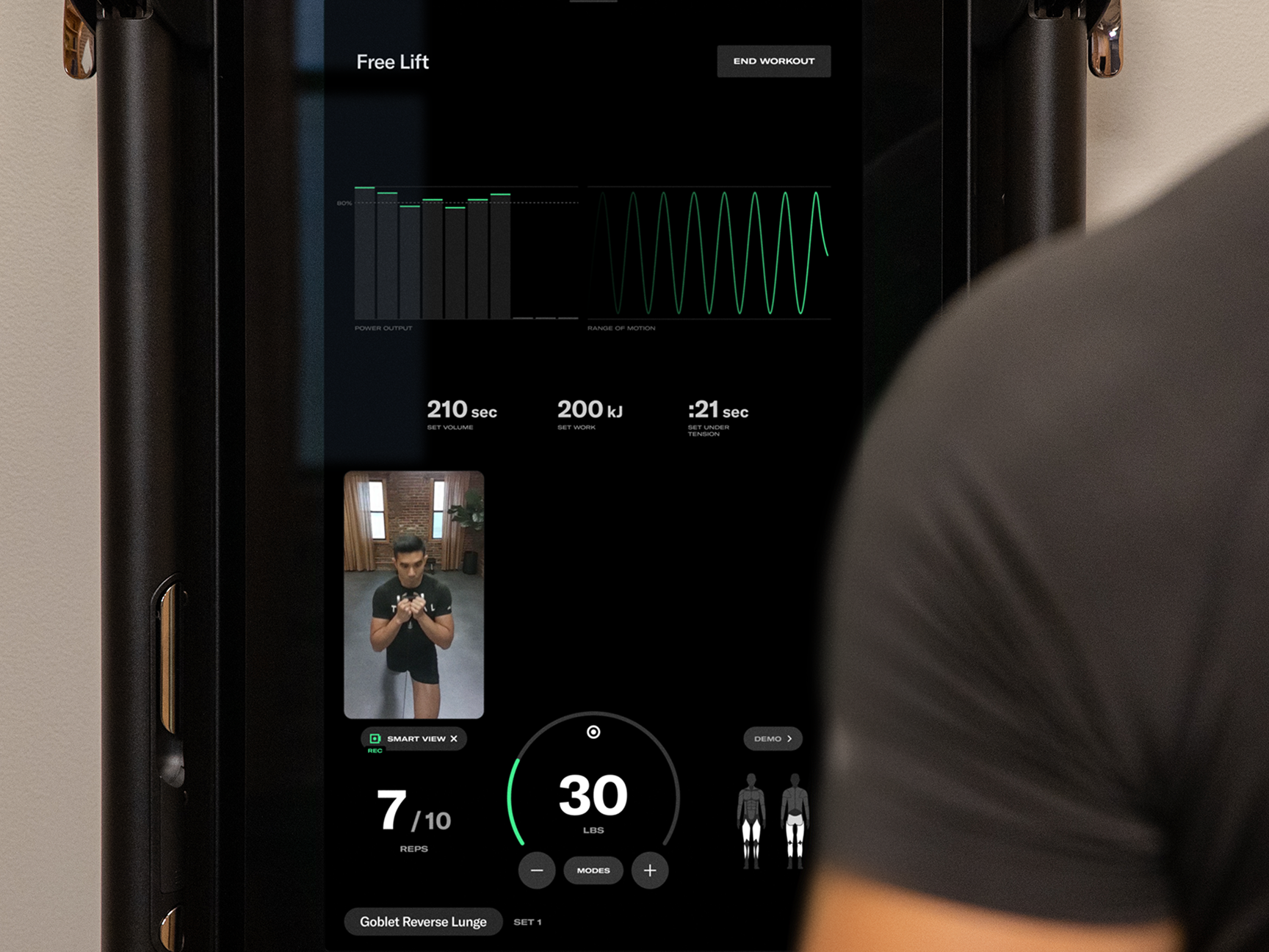 Man in front of Tonal system showing personalized stats
