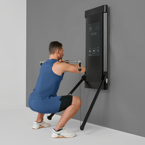 Man using a wall-mounted Tonal machine against a gray background