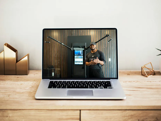 Laptop on desk showing live video call with Tonal expert
