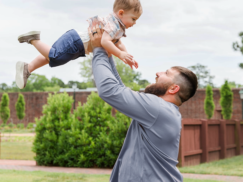 Father holding up young son
