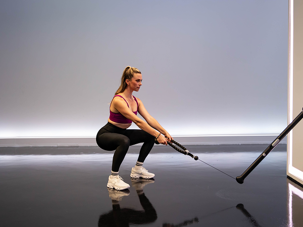 Tonal instructor doing low squat walk out

