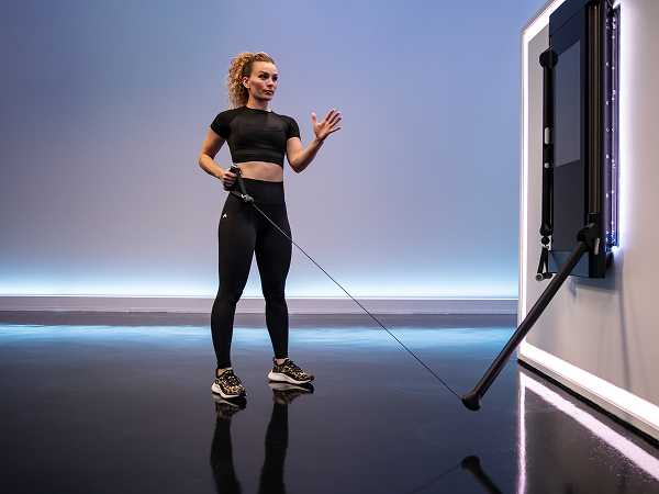 Tonal instructor doing resisted lateral lunge
